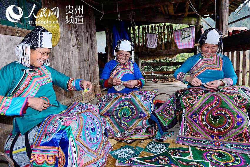 Mulheres da etnia Miao bordam roupas tradicionais para o Ano Novo chinês