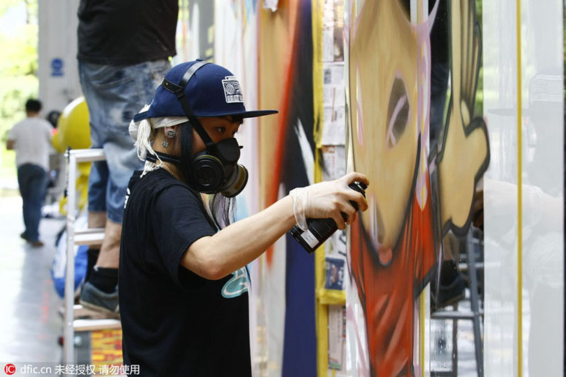 Grafiteiros chineses e estrangeiros pintam trem em Guangzhou