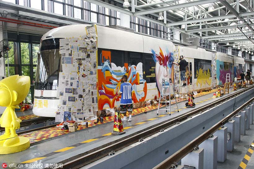 Grafiteiros chineses e estrangeiros pintam trem em Guangzhou