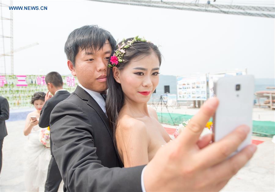 Casais chineses tiram fotos de casamento em ponte suspensa