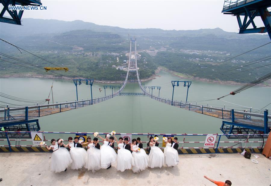 Casais chineses tiram fotos de casamento em ponte suspensa