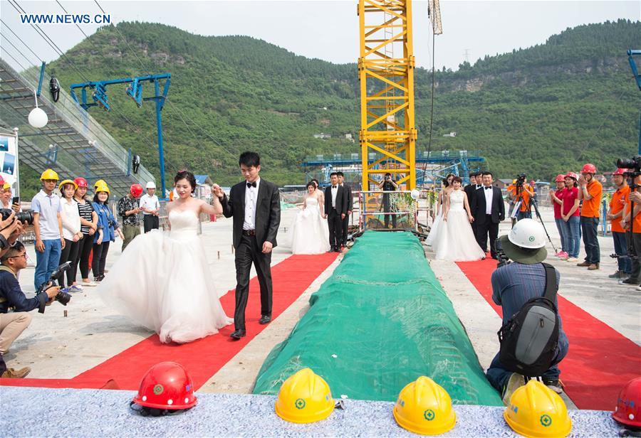 Casais chineses tiram fotos de casamento em ponte suspensa