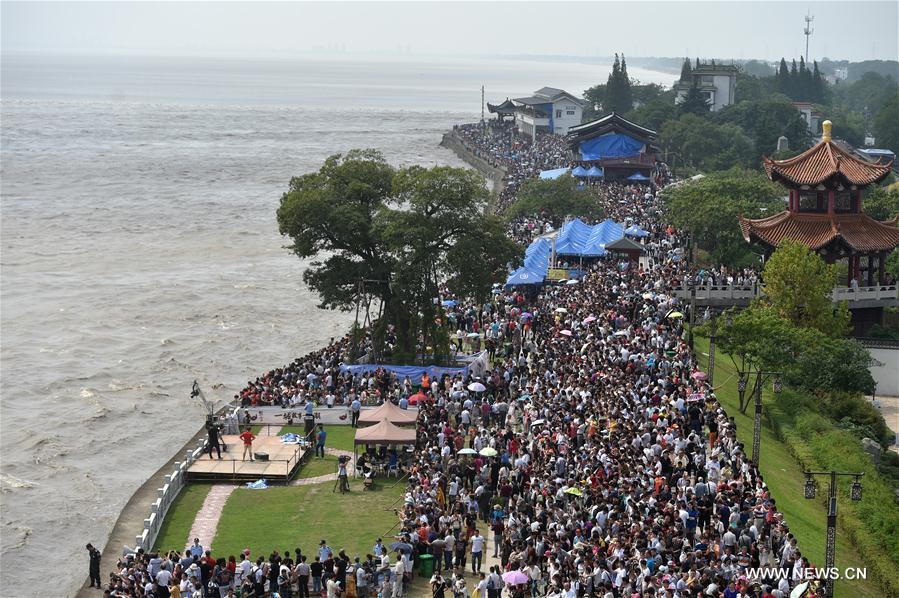 Visitantes observam subida da maré do Rio Qiantang