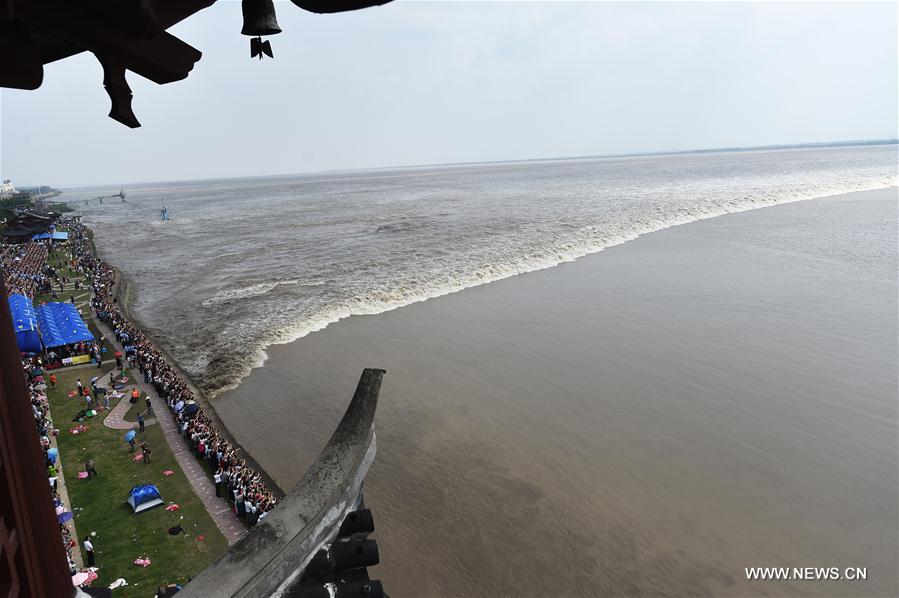 Visitantes observam subida da maré do Rio Qiantang