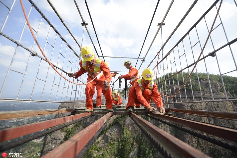 Só para corajosos: Trabalhadores chineses substituem vidro em ponte suspensa a 180 metros do nível do solo