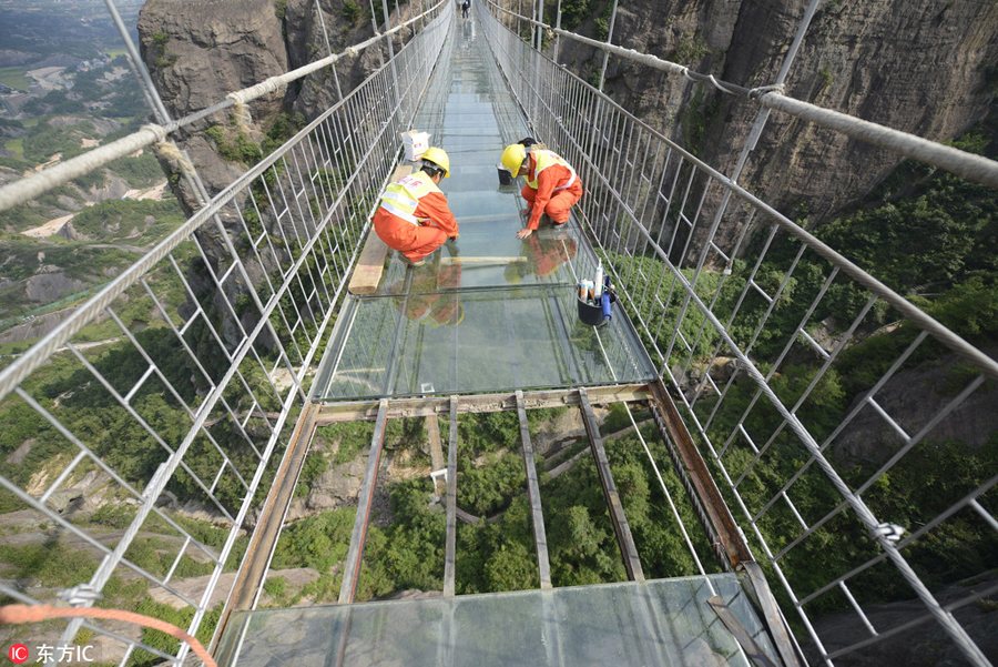 Só para corajosos: Trabalhadores chineses substituem vidro em ponte suspensa a 180 metros do nível do solo