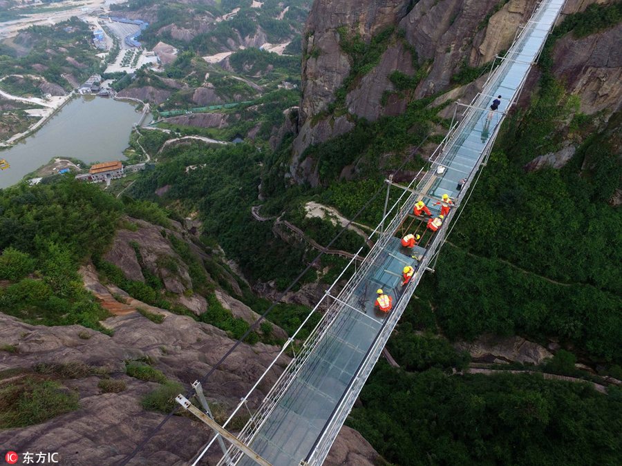 Só para corajosos: Trabalhadores chineses substituem vidro em ponte suspensa a 180 metros do nível do solo