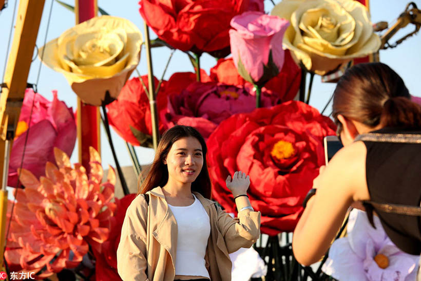 Flores artificiais decoram Praça Tian’anmen para celebrar a chegada do Dia Nacional