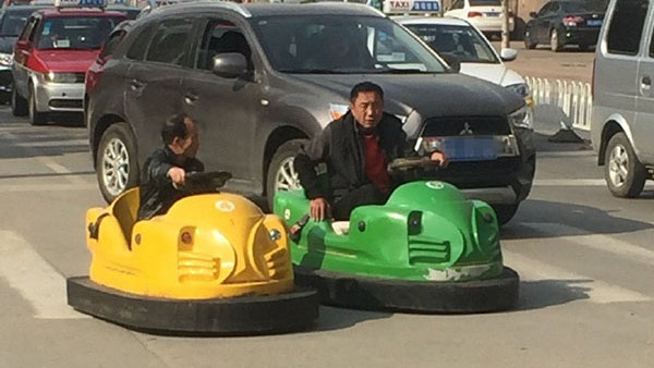 Dois homens conduzem carrinhos de choque nas estradas de Shenyang