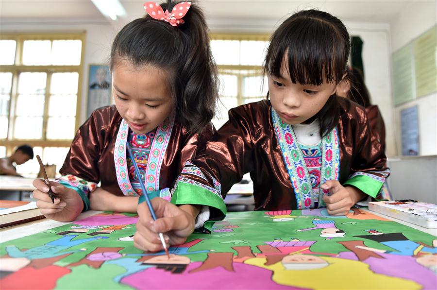 Crianças fazem pinturas de agricultores tradicionais da etnia Dong no sul da China
