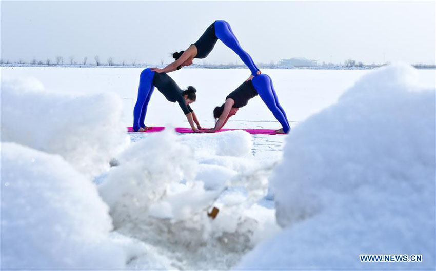 Entusiastas de ioga praticam sobre manto de neve na província de Gansu