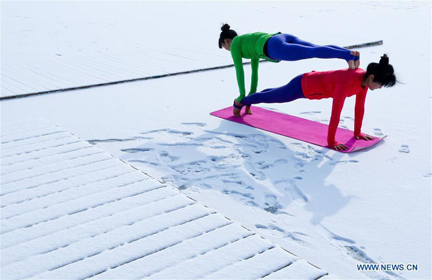 Entusiastas de ioga praticam sobre manto de neve na província de Gansu