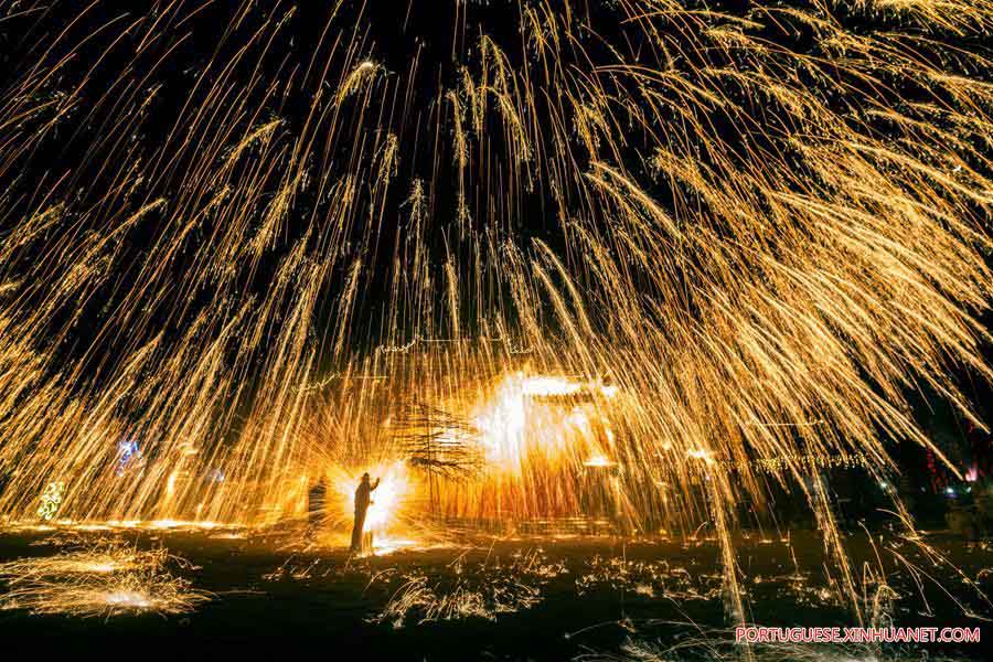 Excutantes espalham ferro derretido quente para simular a exposição dos fogos de artifício em Neihuang