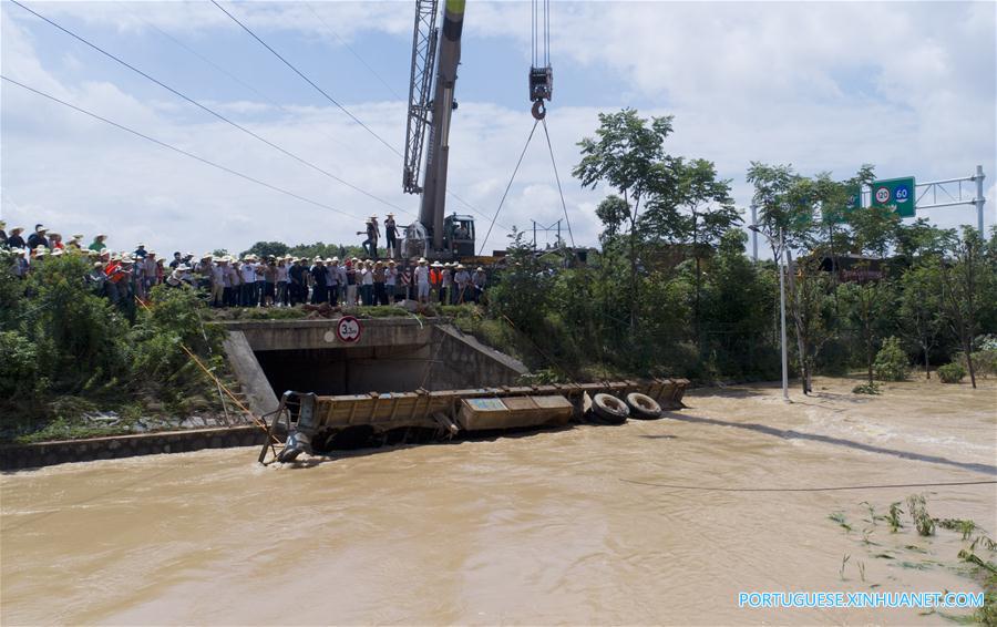 Caminhão reboque é utilizado para bloquear passagem de água em região alagada em Changsha