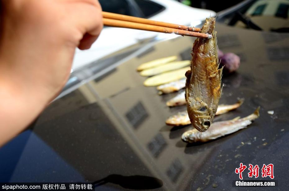 Insólito: Chinesa cozinha em capô de automóvel sob temperatura de 40 graus