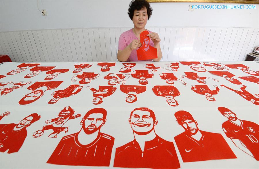 Artesã de Hebei faz cortes de papel com temas da Copa do Mundo