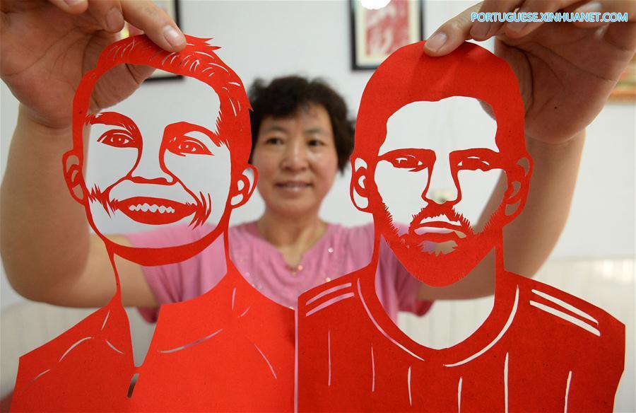Artesã de Hebei faz cortes de papel com temas da Copa do Mundo