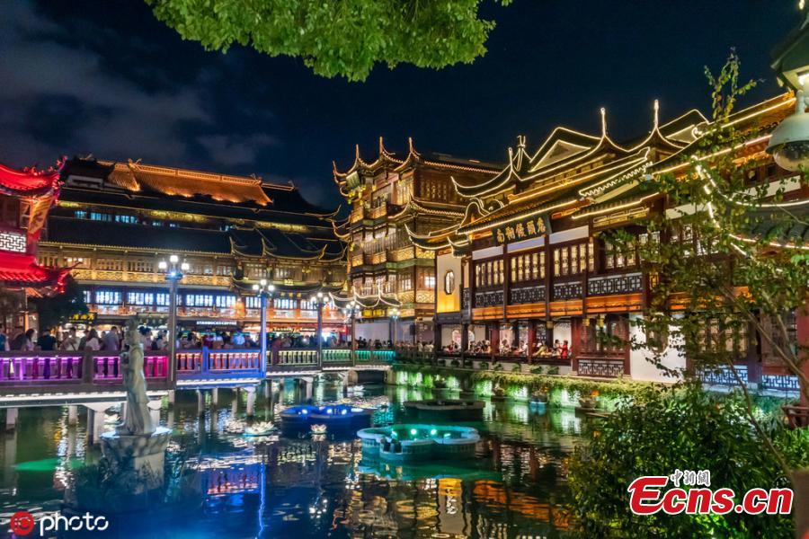 Residentes e turista apreciam o show de 3D nas fachadas dos pavilhões de Hefeng e Huabao no Jardim de Yuyuan, em Shanghai, na noite da quinta-feira (19).