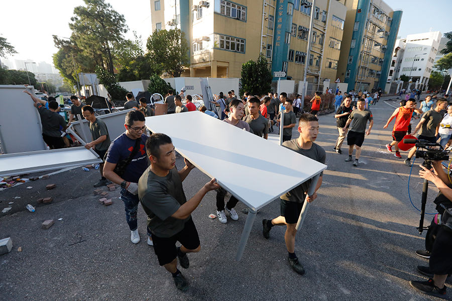 Moradores limpam destroços de protesto deixados durante fim de semana caótico