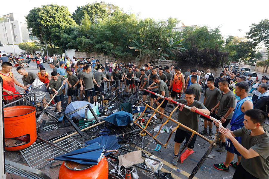 Moradores limpam destroços de protesto deixados durante fim de semana caótico