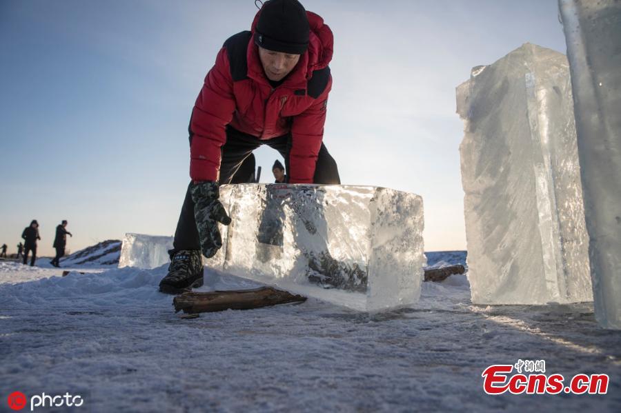 Trabalhadores coletam gelo do rio em Mohe