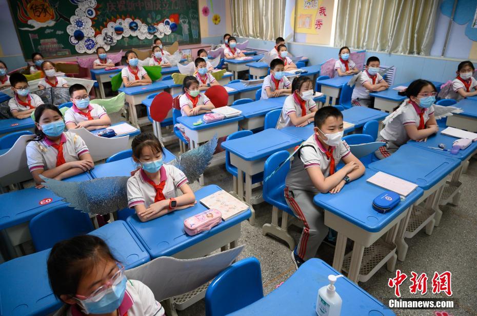China: alunos de escola primária usam “asa de um metro” para manter distanciamento

