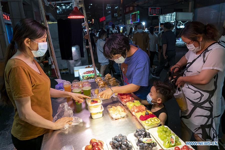 Pessoas visitam mercado noturno em Wuhan