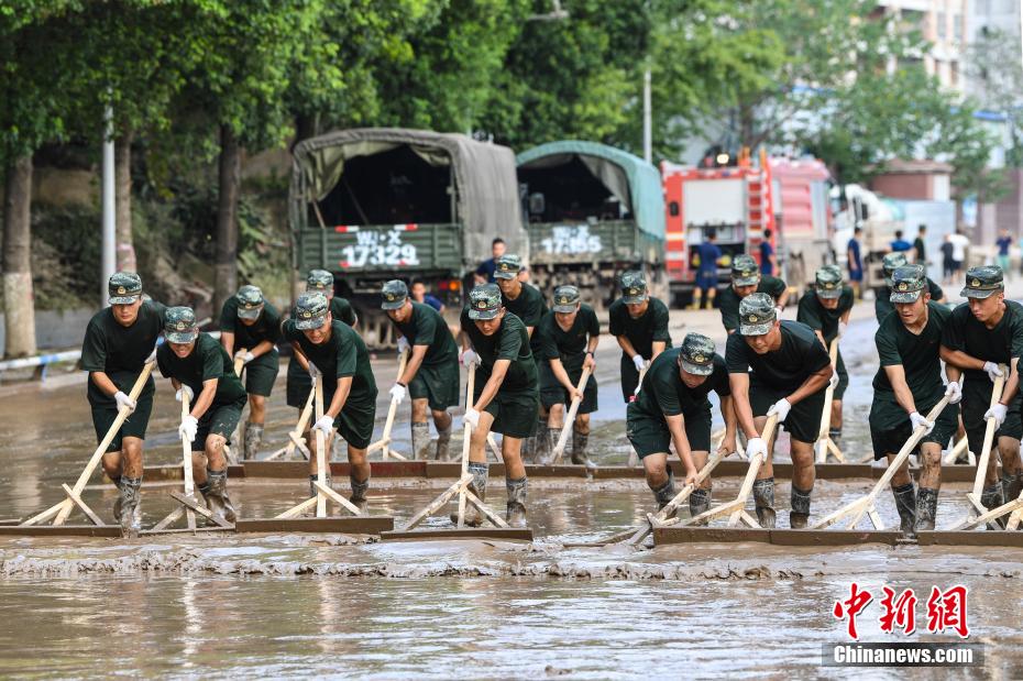 Oficiais e soldados limpam lama depois da inundação em Chongqing