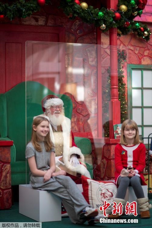 Papai Noel interage com crianças por vidro durante pandemia