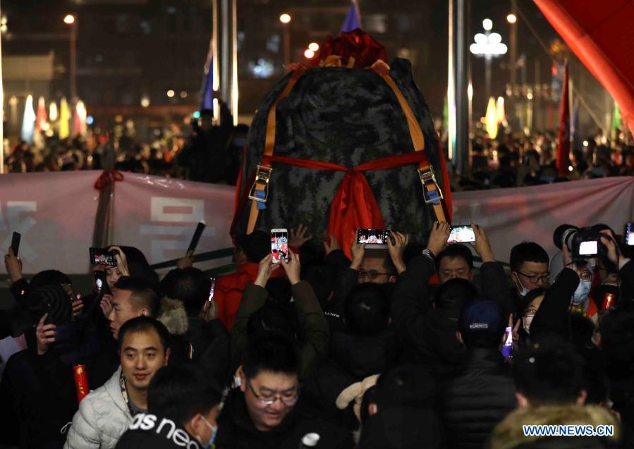 Pessoas comemoram a chegada da cápsula de retorno da sonda Chang'e-5 em Beijing