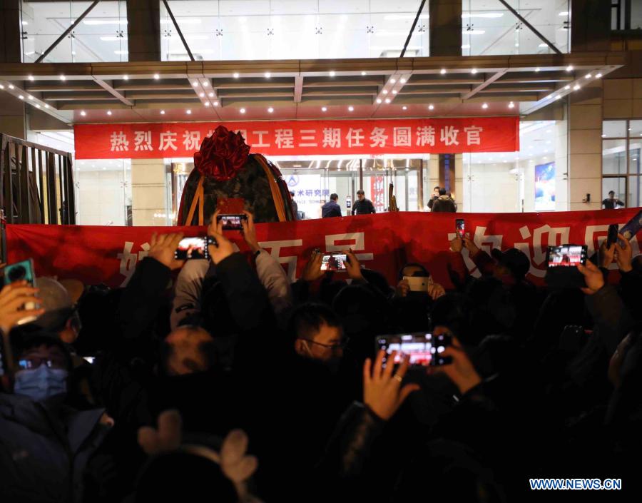 Pessoas comemoram a chegada da cápsula de retorno da sonda Chang'e-5 em Beijing