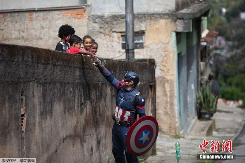 Policiais brasileiros vestidos de super-heróis interagem com crianças