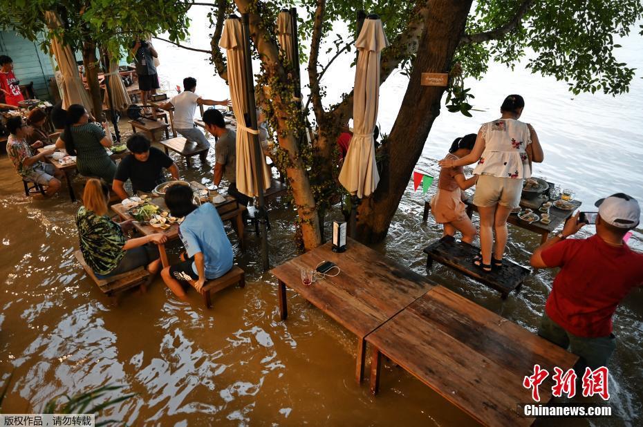 Tailândia: clientes comem em restaurante inundado