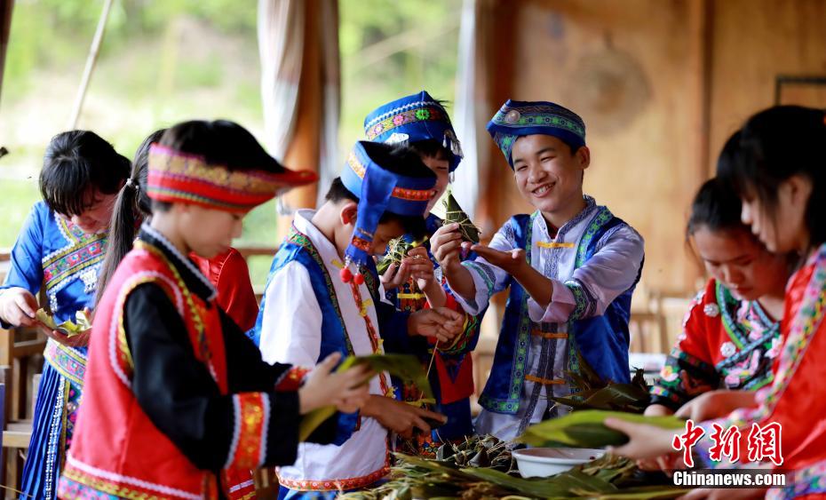 Pessoas fazem “zongzi” para receber Festival do Barco do Dragão em Guangxi