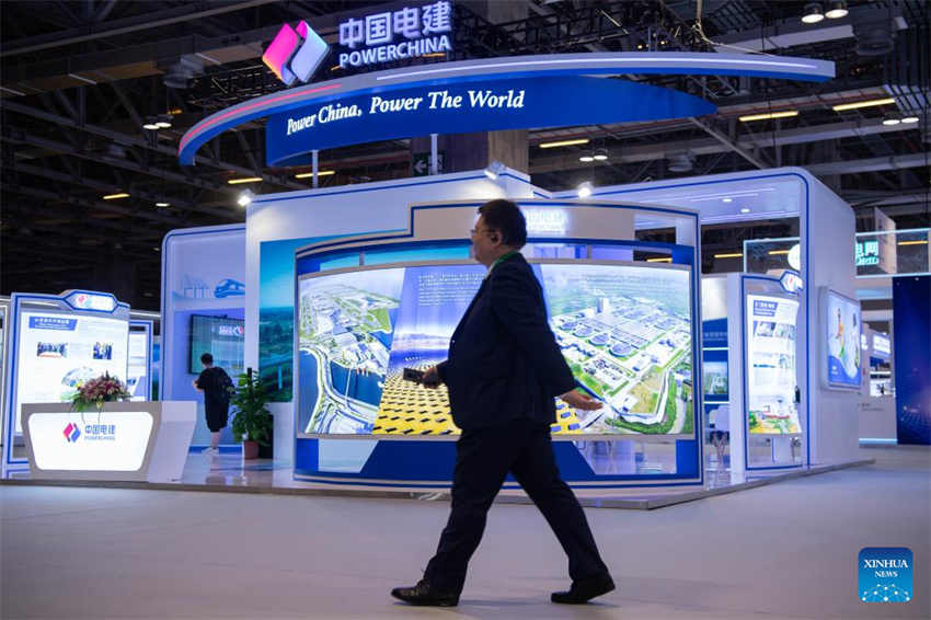 Um participante passa pela área de exposição da Power Construction Corporation of China durante o 14º Fórum Internacional sobre o Investimento e Construção de Infra-estruturas em Macau, no sul da China, em 1º de junho de 2023. (Foto: Cheong Kam Ka/Xinhua)