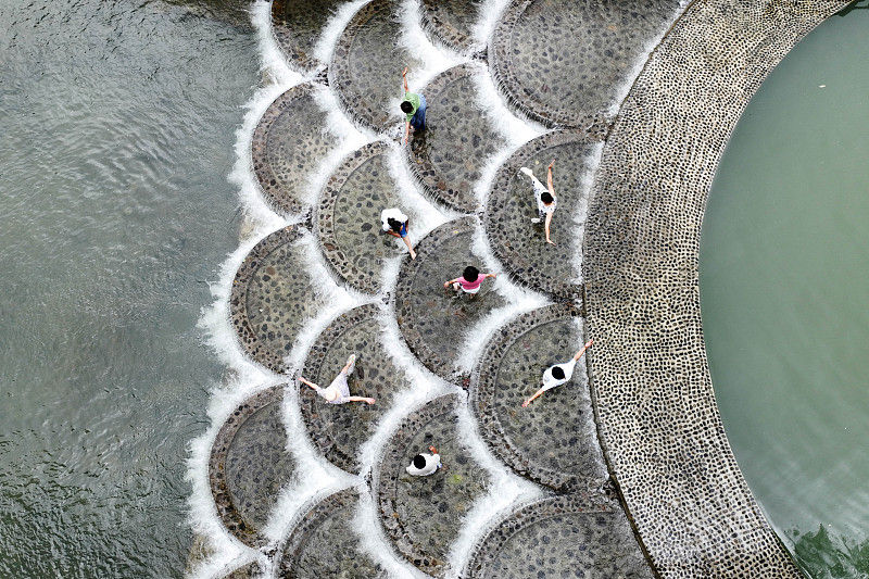Turistas brincam com água na barragem para passar calor, sudoeste da China