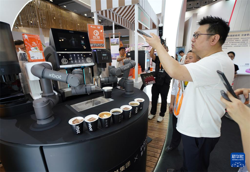 No estande do Grupo Wangfujing, o robô barista Xbot prepara café para os visitantes.