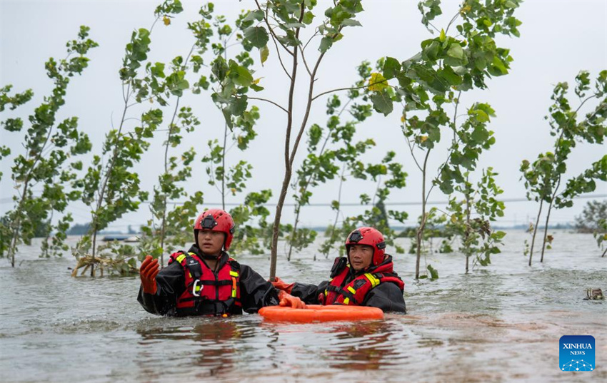 Equipe de resgate drena águas de inundação num dique do Lago Dongting em Tuanzhou, condado de Huarong, província de Hunan, centro da China, em 9 de julho de 2024.