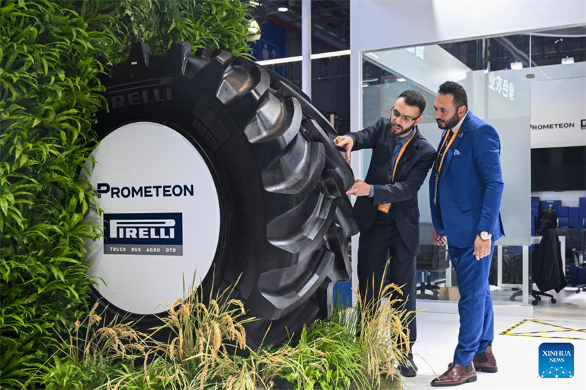 Expositores discutem sobre o pneu agrícola ATO2 da Prometeon, que fez sua estreia na Ásia, na área de exposição de Automóveis e Mobilidade Inteligente, durante a 8ª Exposição Internacional de Importação da China (CIIE), em Shanghai, no leste da China, em 6 de novembro de 2025.