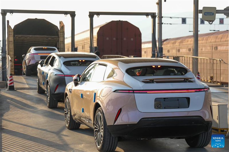 Veículos de nova energia fabricados em Chongqing, com destino à exportação, são conduzidos para um trem de carga em uma base logística de veículos comerciais em Chongqing, sudoeste da China, em 29 de novembro de 2025.