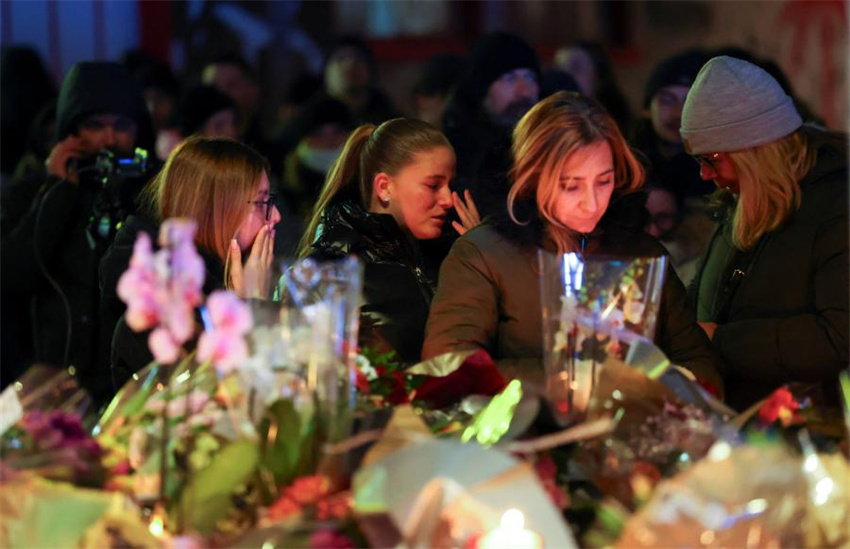 Pessoas em luto se reúnem para deixar flores e velas no local após um incêndio ter eclodido durante a madrugada no bar Le Constellation, em Crans-Montana, na Suíça, em 1º de janeiro de 2026.