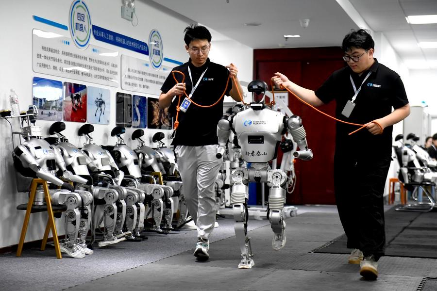Funcionários ajustam um robô na Shandong Yobotics Intelligent Robot Co., Ltd., na Zona de Desenvolvimento Industrial de Alta Tecnologia de Jinan, na província de Shandong, leste da China, em 11 de julho de 2026. (Foto: Guo Xulei/Xinhua)