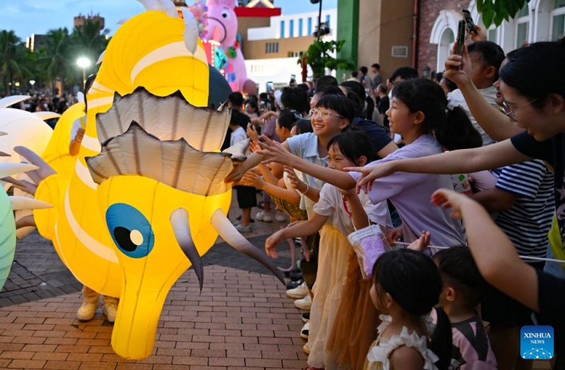 Uma artista interage com o público durante um desfile de carnaval em Haikou, na província de Hainan, sul da China, em 18 de julho de 2026. (Foto: Guo Cheng/Xinhua)