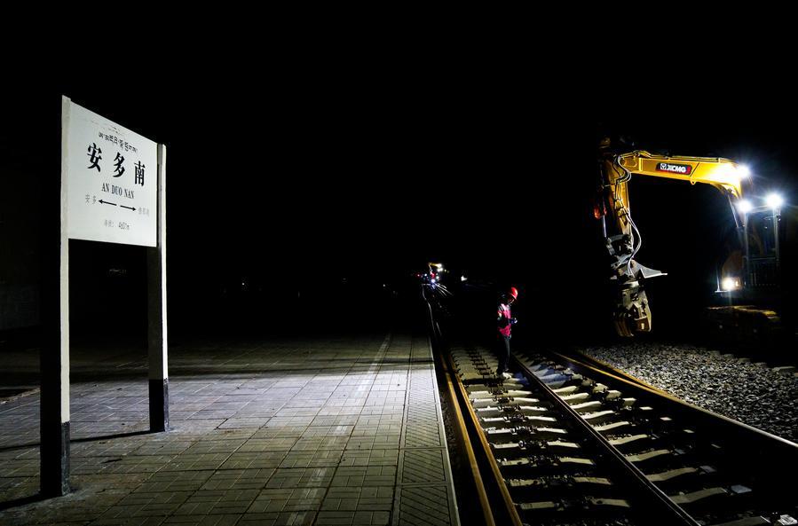 Trabalhadores substituem trilhos por trilhos contínuos na Ferrovia Qinghai-Xizang, em Amdo