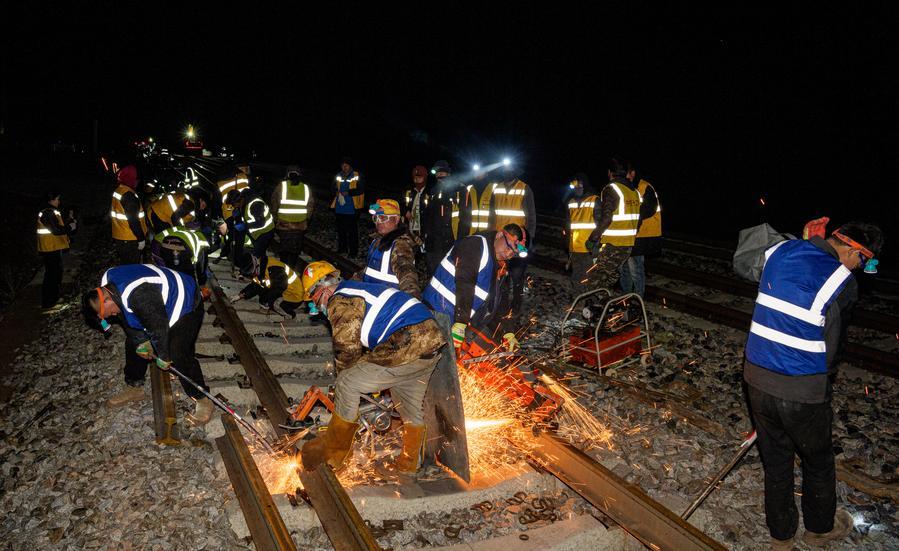 Trabalhadores substituem trilhos por trilhos contínuos na Ferrovia Qinghai-Xizang, em Amdo